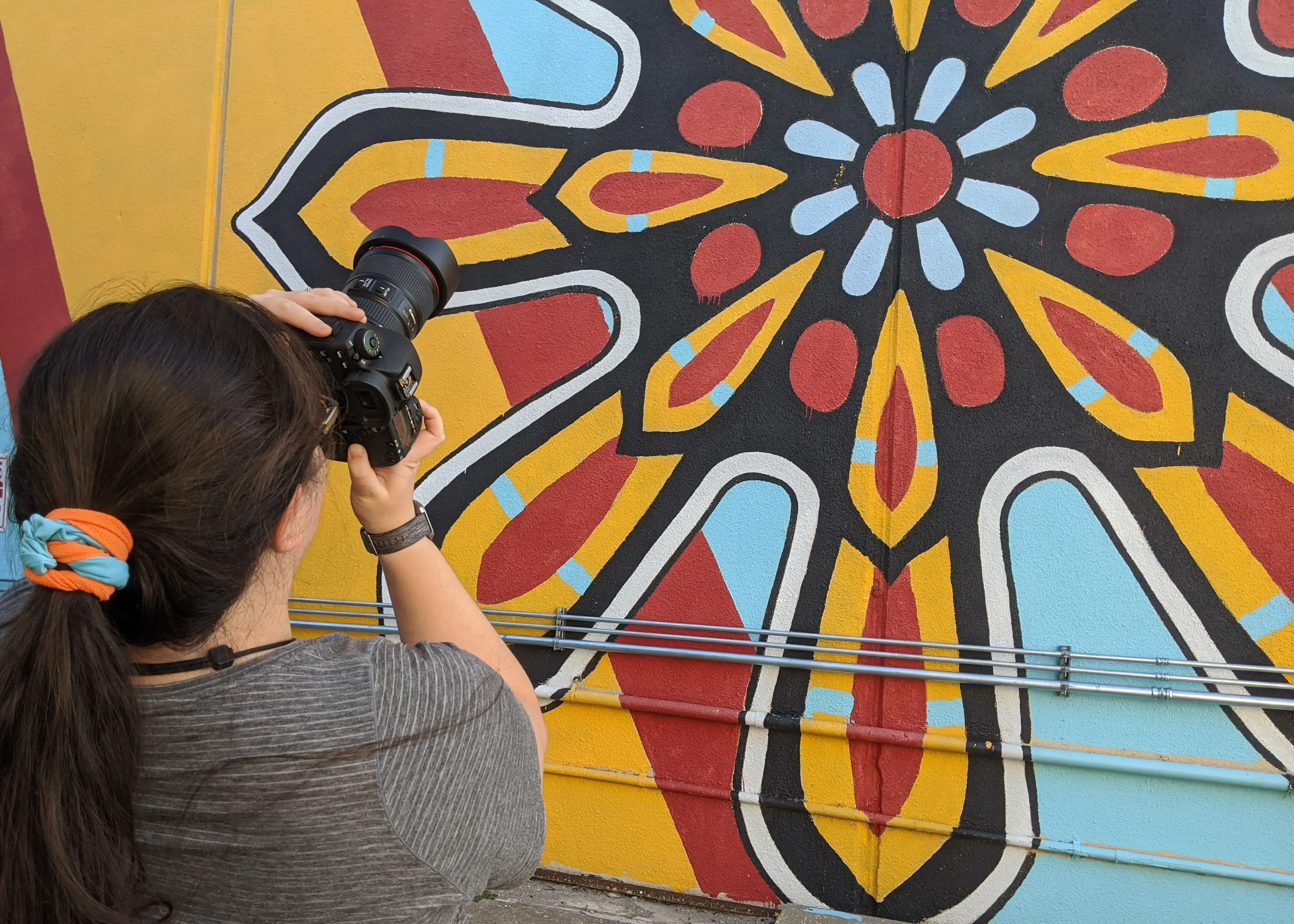 Grace Hammonds standing at an art wall in Norman, Oklahoma
